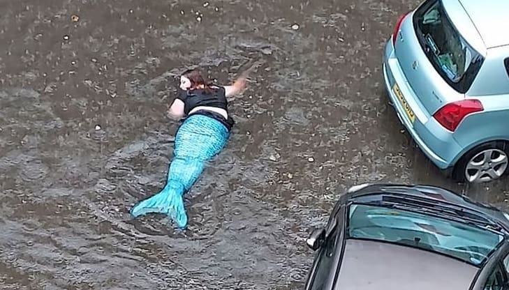 Mulher aproveita enchente para bancar a sereia em ruas alagadas