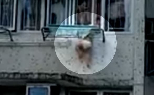 Video de criança pendurada na janela de prédio causa desespero
