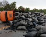 Caminhão com carvão bate em carro e tomba, na BR-494 em Nova Serrana