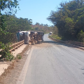 Carreta carregada com café tomba na BR-354 em Bambuí; parte da carga cai no rio