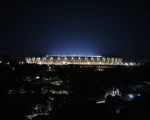 Vista panorâmica e noturna do Estádio do Mineirão totalmente iluminado sob o céu escuro.