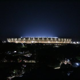 Vista panorâmica e noturna do Estádio do Mineirão totalmente iluminado sob o céu escuro.